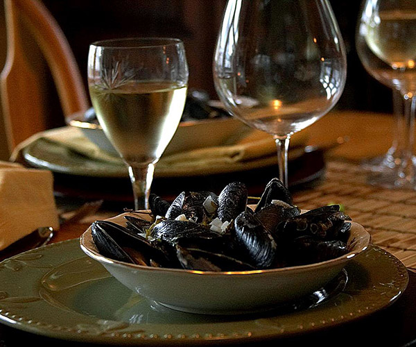 Plate of stuffed mussels with a glass of white wine