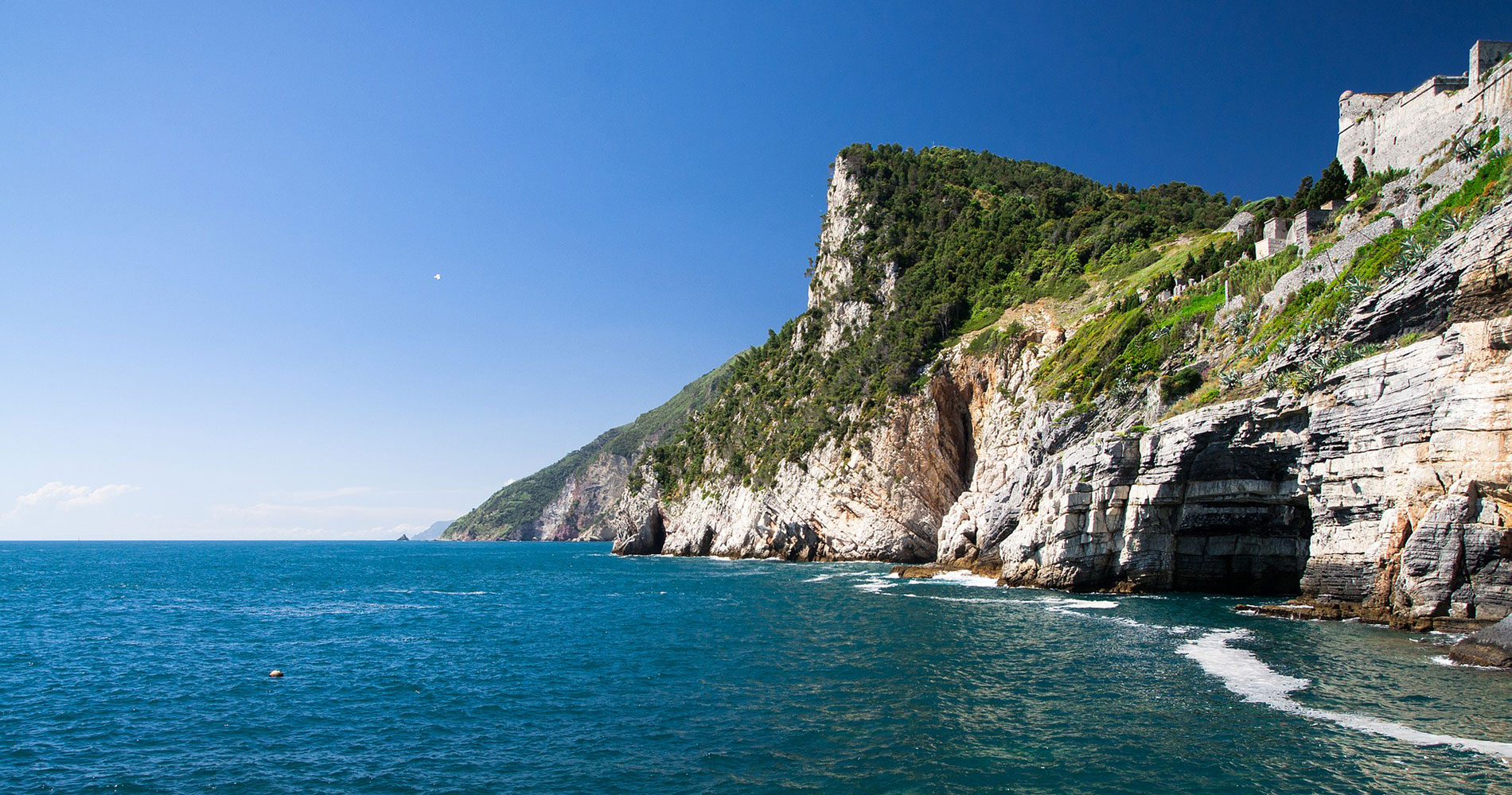View from the sea of the natural rock climbing wall of Porto Venere